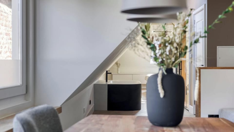 Natural textures meet modern materials — a soft floral accent on a sleek dining table.