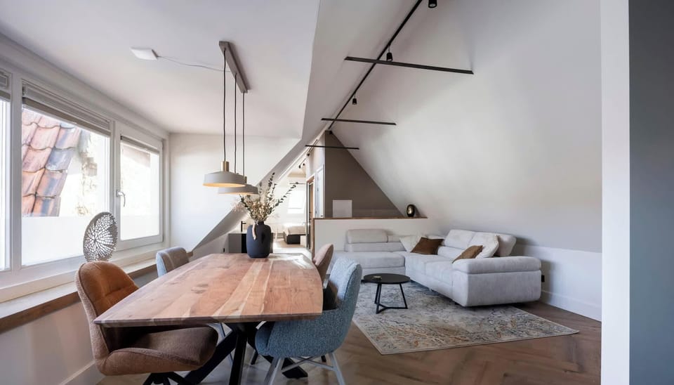 A stylish dining table with natural and industrial lighting — perfect for relaxed meals or remote work.