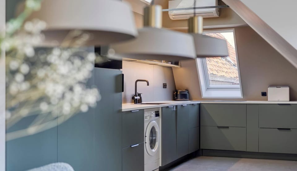 Modern kitchen with matte green cabinetry, black fixtures and clever built-in storage.