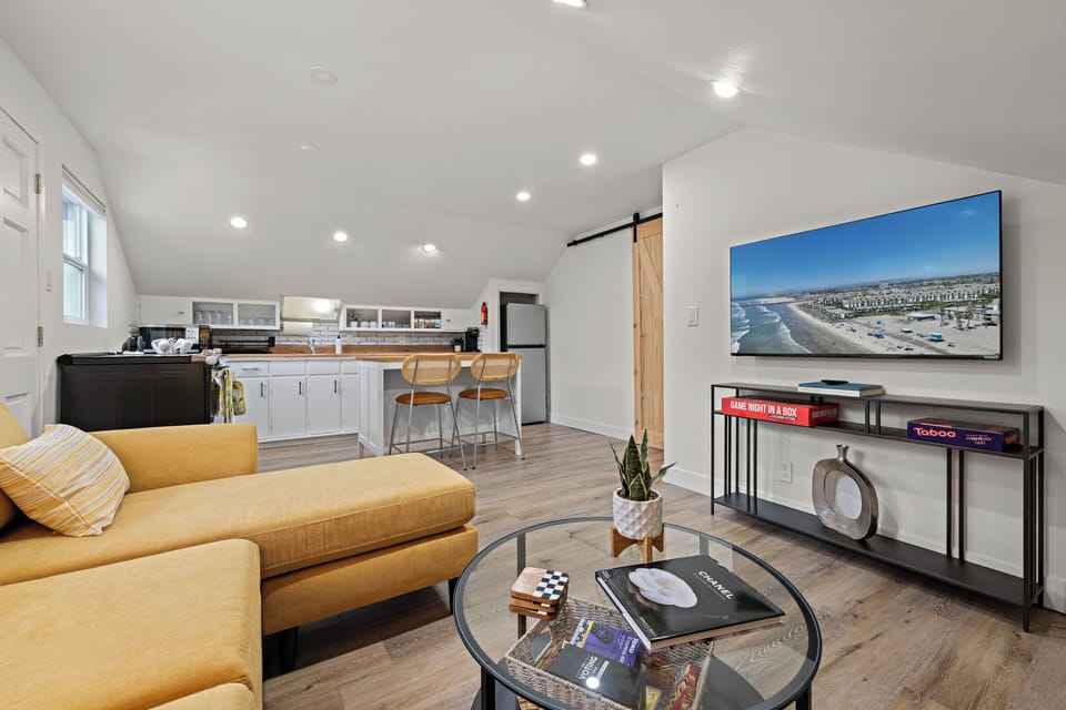 Open-concept living area with smart TV, comfy seating, and a equipped kitchen.