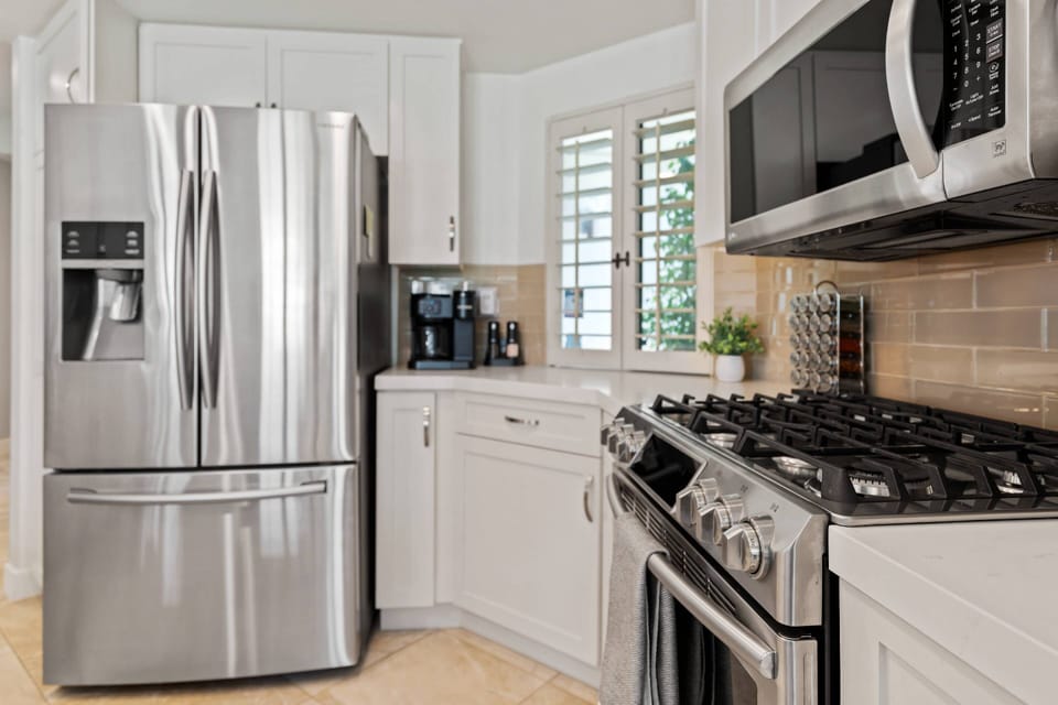 Stainless Steel French door fridge, oven, microwave, coffee maker, and ample prep space.