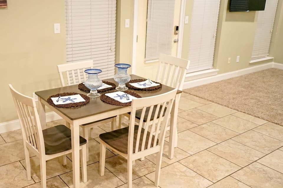 Bright 4-seat dining area with stylish table setting and open layout