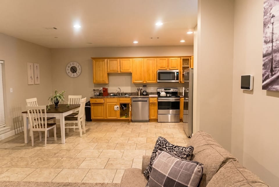 Bright open kitchen with dining for 4 and sleek stainless appliances