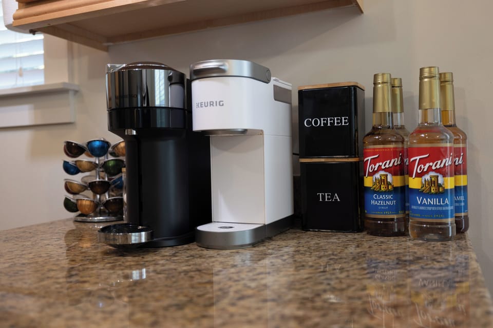 Dedicated coffee bar stocked with syrups, sugar and coffee-mate and mugs. 