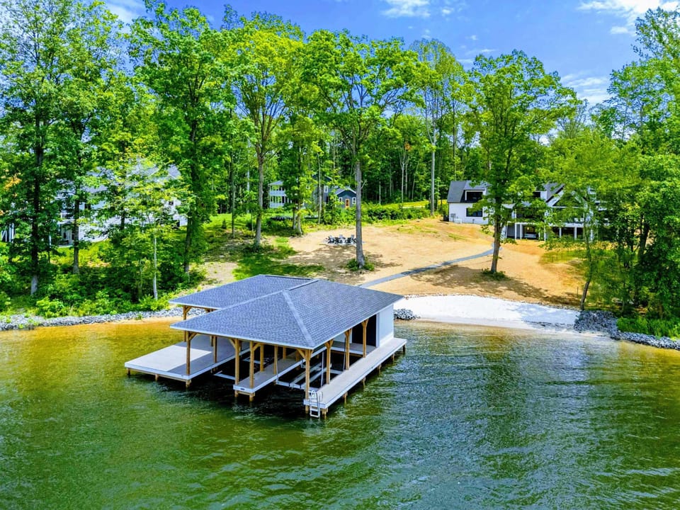 Aerial View - Beach, dock, fire pit, and the full lakefront property from above, showing everything within easy reach.