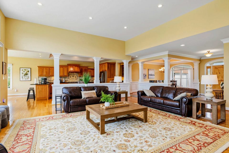Great Room - From the entry, the open layout draws you in with hardwood floors, warm tones, and the kitchen columns framing the space.