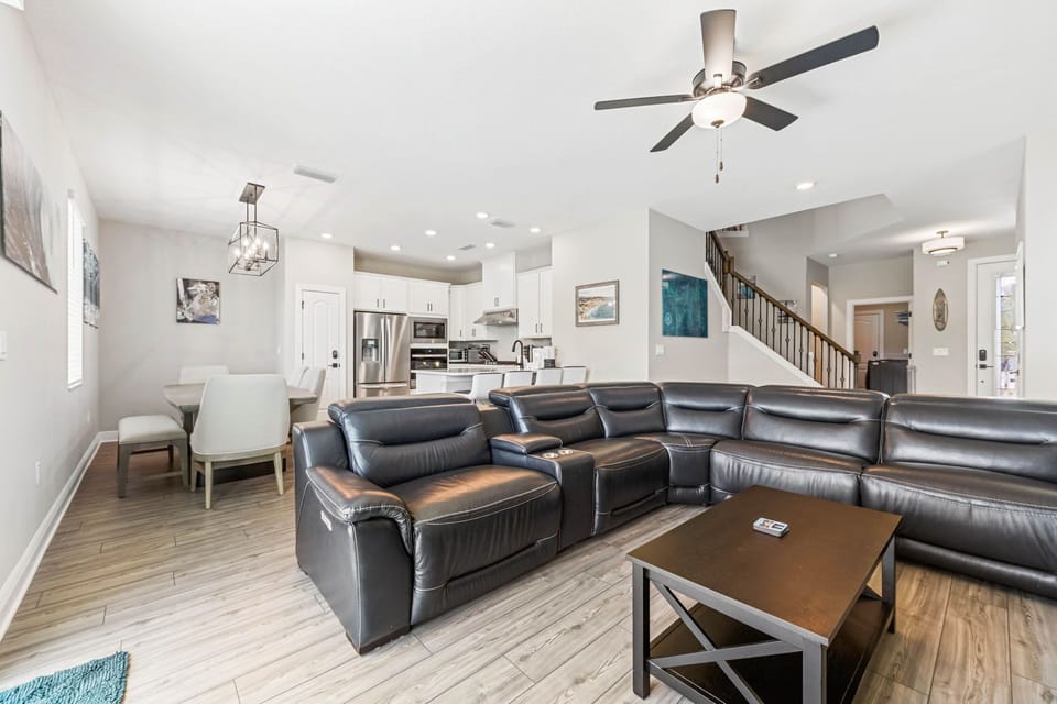 Spacious open-plan living room with leather seating and modern kitchen for family gatherings.