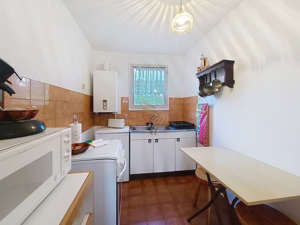 Cette cuisine pratique offre tout le nécessaire pour cuisiner des repas simples. Profitez de cet espace fonctionnel avec une belle lumière naturelle pour préparer vos plats préférés.