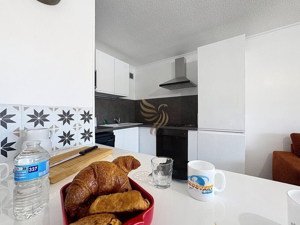 La cuisine moderne est équipée pour vos repas conviviaux. Le plan de travail spacieux invite à cuisiner ou à déguster vos croissants du matin, créant une ambiance chaleureuse idéale pour commencer la journée.