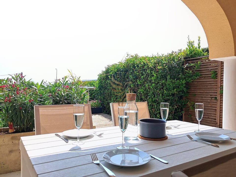 Terrasse aménagée pour des repas en plein air dans un cadre verdoyant.