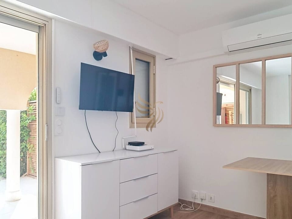 Séjour moderne et épuré avec TV écran plat et mobilier pratique.