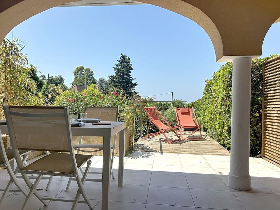 Terrasse ombragée avec mobilier de jardin, idéale pour vos repas en extérieur.