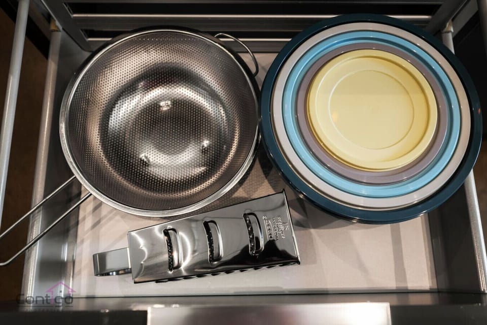 Drawer with cookware, bowls, and utensils to make cooking easy and convenient.
