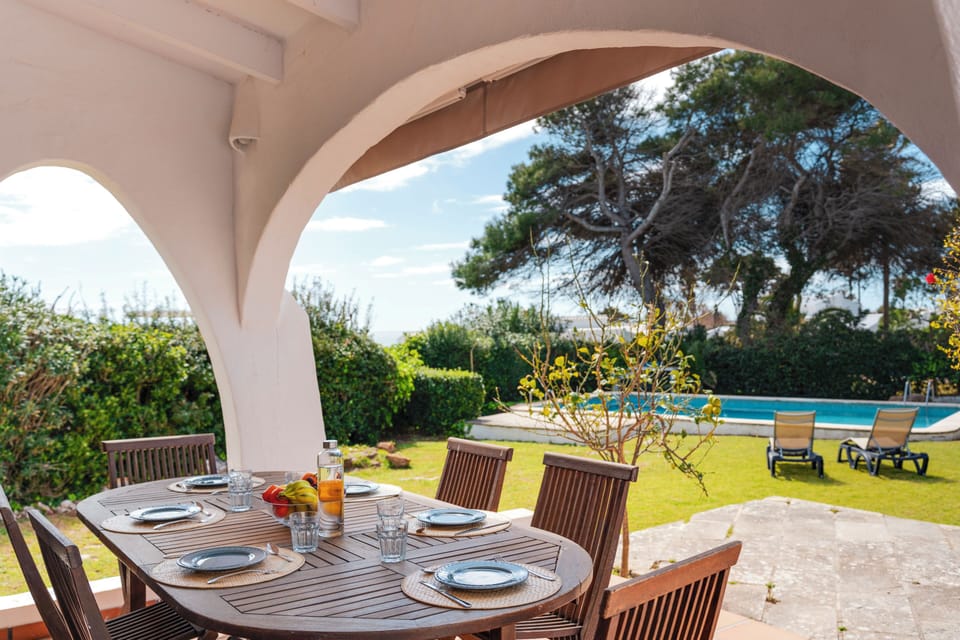Porche exterior cubierto con comedor, mesa para 6 y vistas a la piscina privada