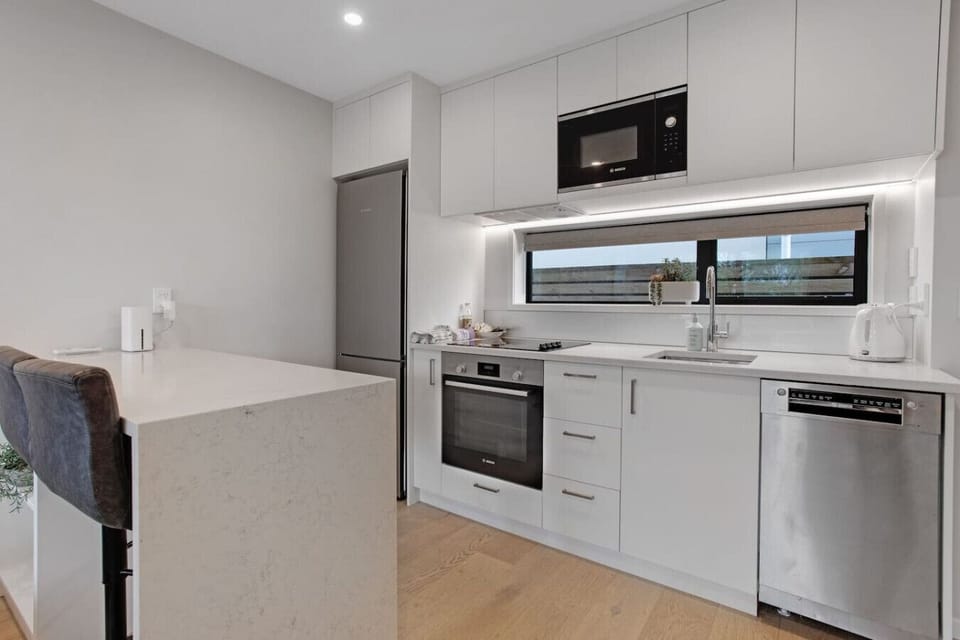 The kitchen has an oven, cooktop, dishwasher, microwave and fridge/freezer.