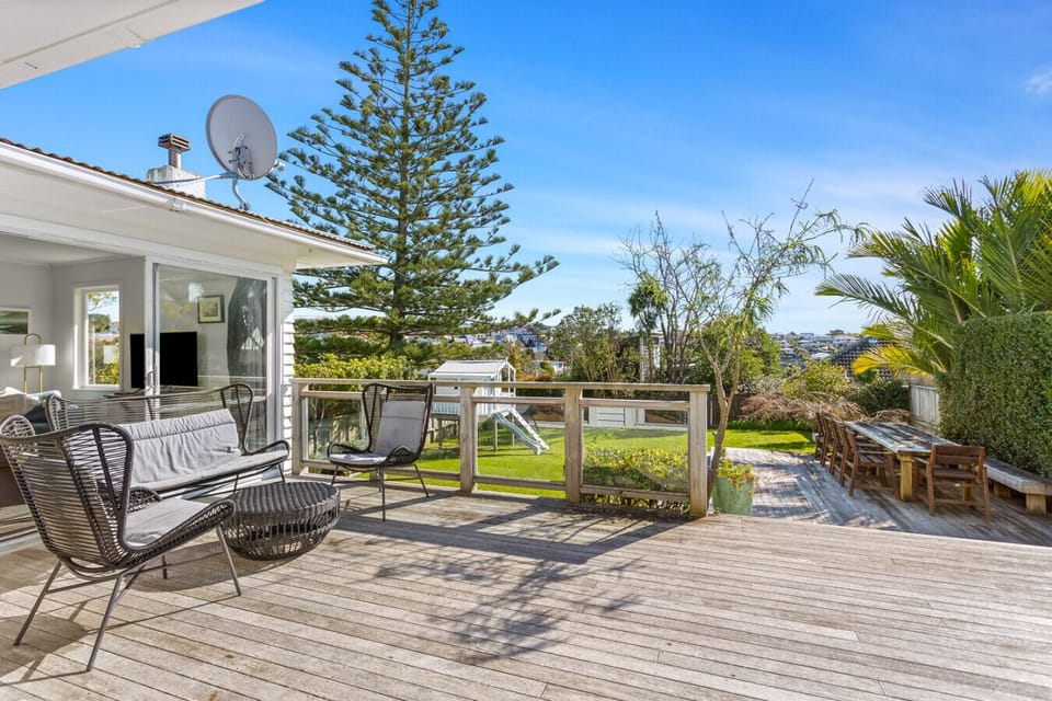 Deck with outdoor seating, garden views, and a spacious lawn.