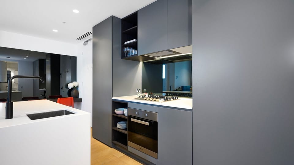 A designer kitchen featuring moody grey cabinetry and high-end integrated appliances