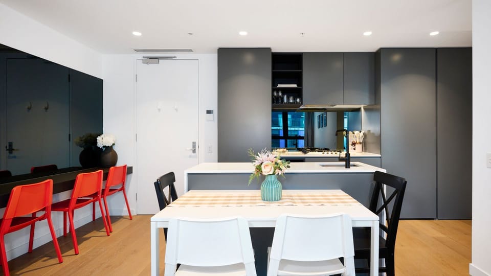 A versatile dining and work zone featuring vibrant red chairs for a modern edge