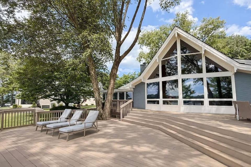 Two story windows and a 2000 square feet deck overlooking the lake, tucked under the mature river birch trees is truly unique!