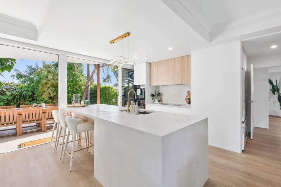A spacious, modern kitchen designed for comfort and style. Includes a generous island bench with seating, dishwasher and ample storage, offering an easy, social space for cooking, gathering and hosting during your stay.