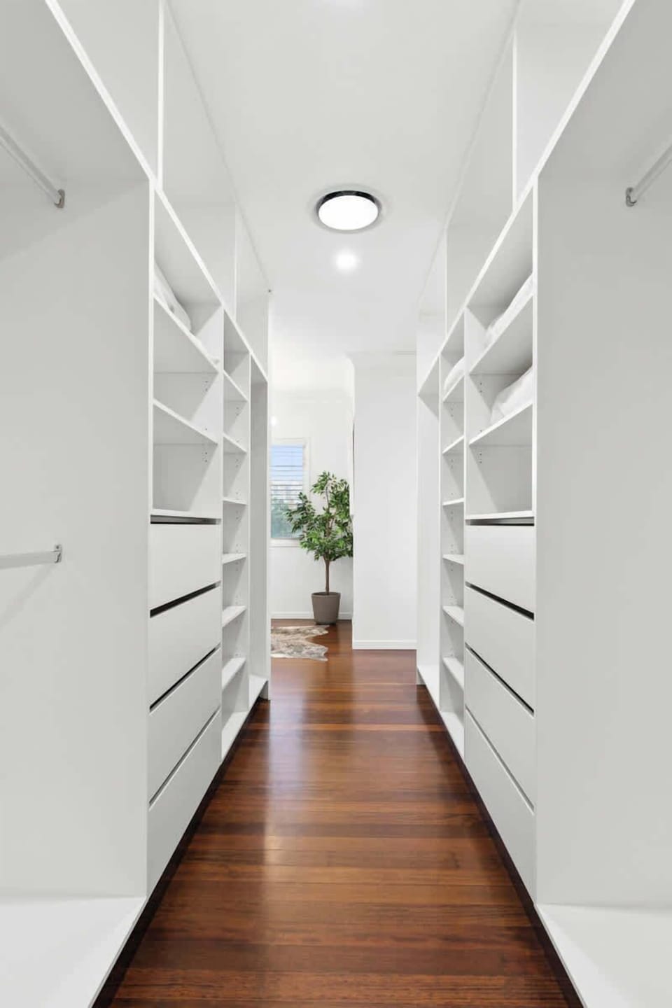 Impressive walk-in dressing room with extensive shelving, drawers and hanging space on both sides. Light, spacious and beautifully organised, offering a boutique-style experience within the master suite.