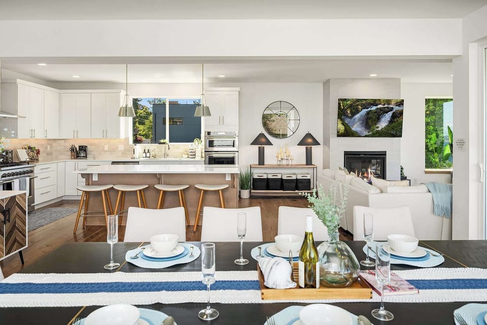Fireplace lounge + dining area + gourmet kitchen, all under an open vaulted ceiling.