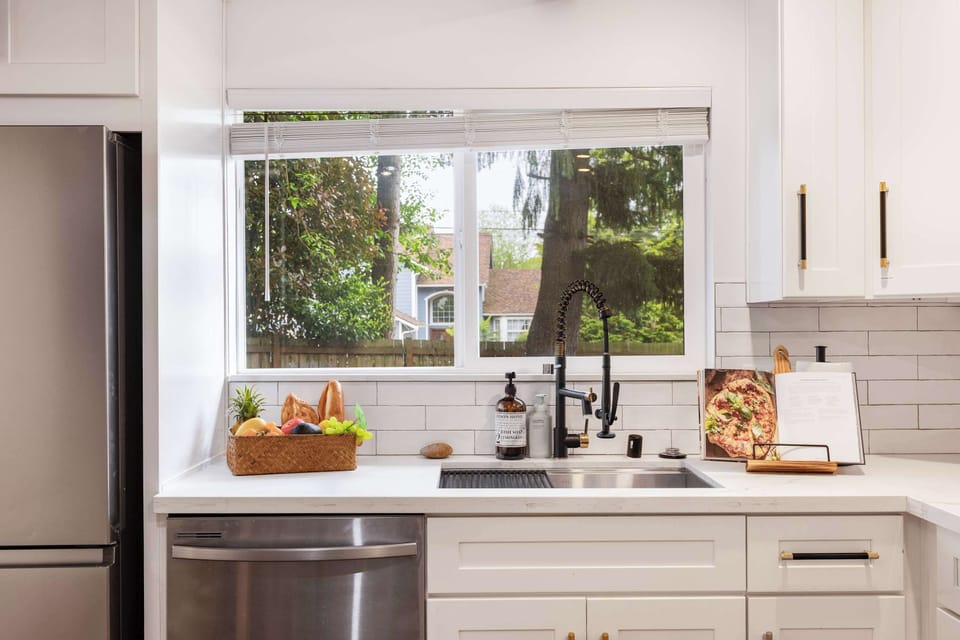 Well-equipped with a deep sink, recipe book stand, and natural light from the large window.