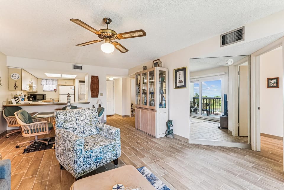 - Spacious living room with tile floors cozy seating and bright natural lighting  
- Open floor plan connects kitchen dining and balcony access for easy flow space  
- A welcoming area perfect for relaxing family nights or vacation gatherings  
