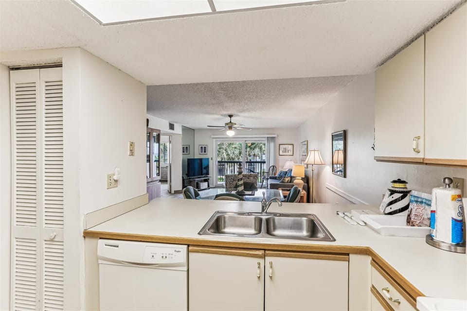 - Bright kitchen pass through overlooks open living dining room with balcony view  
- Well equipped with sink stove dishwasher and ample prep space for easy cooking  
- A practical open layout that connects meals with relaxation and conversation  
