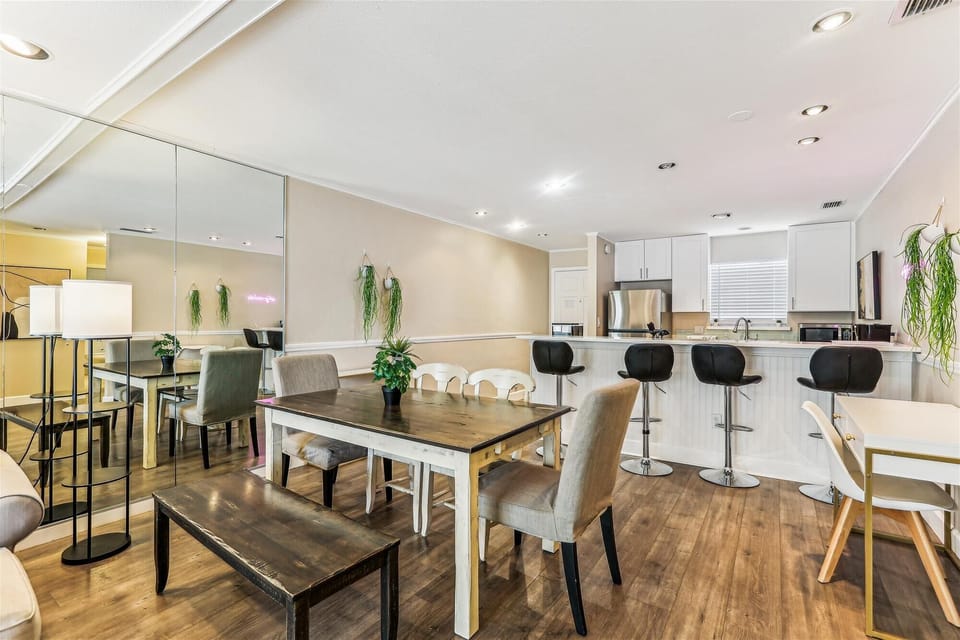 - Spacious dining table with chairs and bench seating for family meals  
- Breakfast bar with stools connects to fully equipped modern kitchen  
- Stylish decor accents and indoor plants enhance the warm atmosphere  