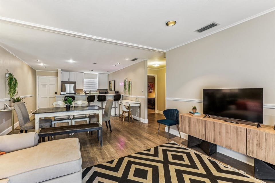 - Spacious open floor plan with living room, dining table, and breakfast bar seating  
- Modern kitchen featuring stainless steel appliances and ample counter space  
- Perfect for group gatherings with stylish lighting and easy flow throughout  