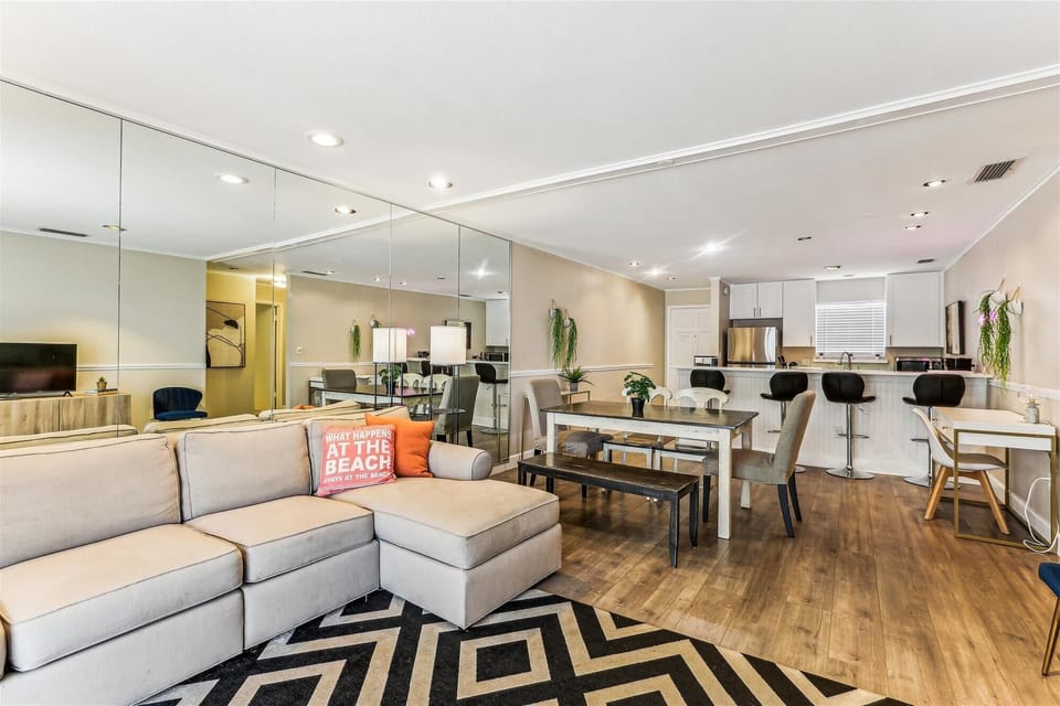 - Open concept living area with sectional sofa and accent pillows  
- Dining space with modern table and seating for family gatherings  
- Fully equipped kitchen with breakfast bar overlooking the room  
