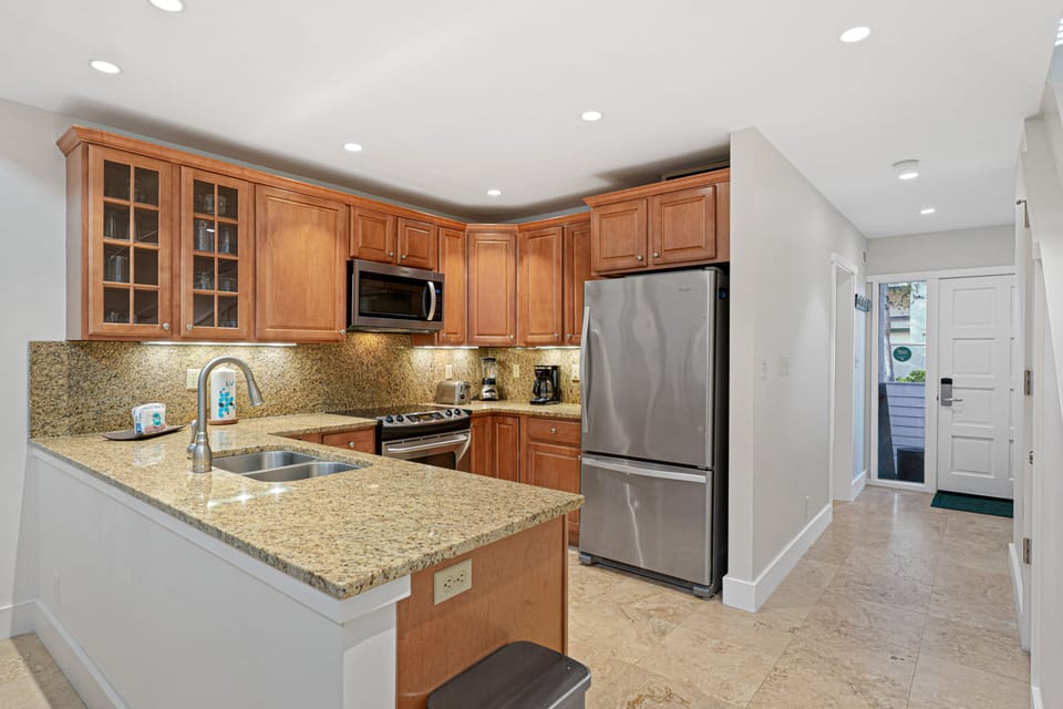 Recessed lighting brightens the space, while the peninsula layout keeps the cook connected to the dining and living areas