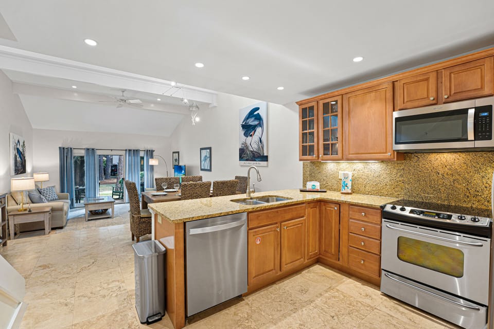 Granite counters, a deep stainless sink, and bar seating make this a practical hub for meals, conversation, and relaxing after a day on the island.