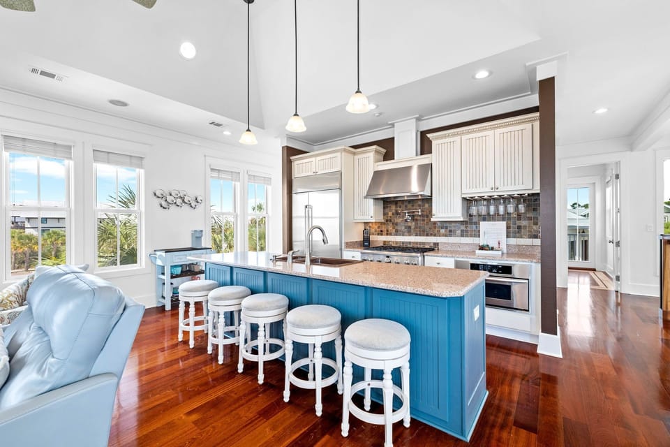 Your gourmet kitchen features a stunning blue island, granite countertops, and stainless steel appliances - perfect for creating memorable meals together.