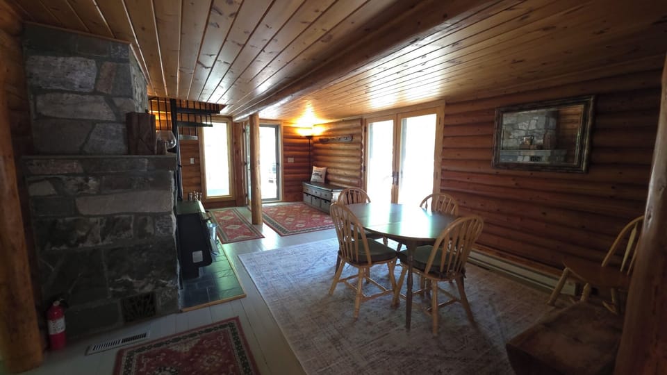 Open dining area with stone fireplace, and spiral staircase.