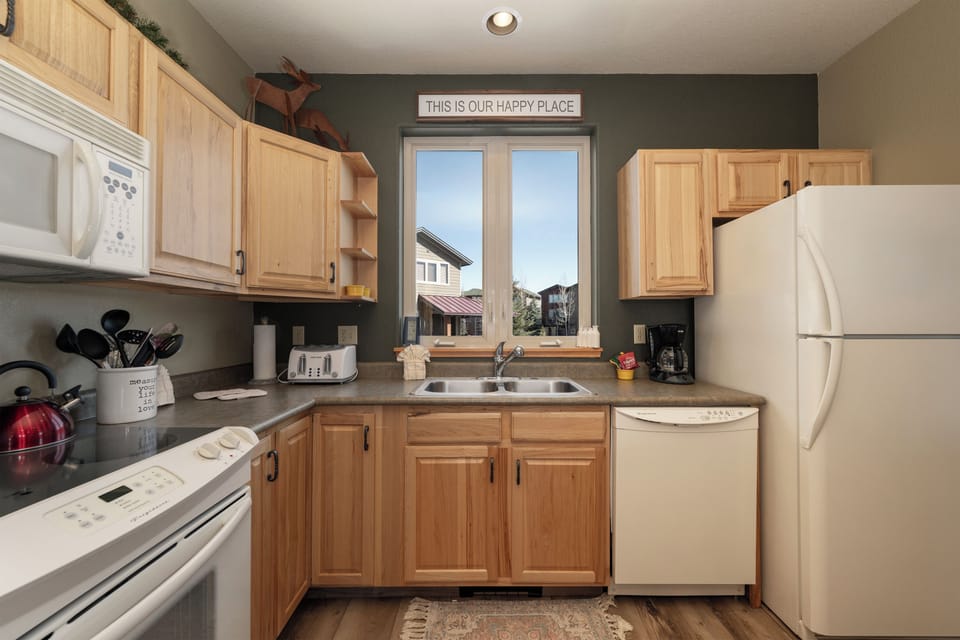 Cook your favorite meals in this fully equipped kitchen with modern appliances and warm wood cabinets.