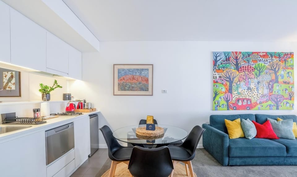 A contemporary dining and living area combination featuring bold artwork and comfortable furniture.
