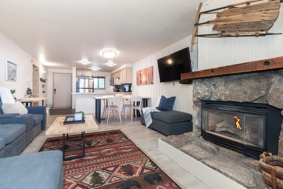 Cozy up by your crackling stone fireplace in this modern mountain retreat, where rustic charm meets contemporary comfort perfectly.