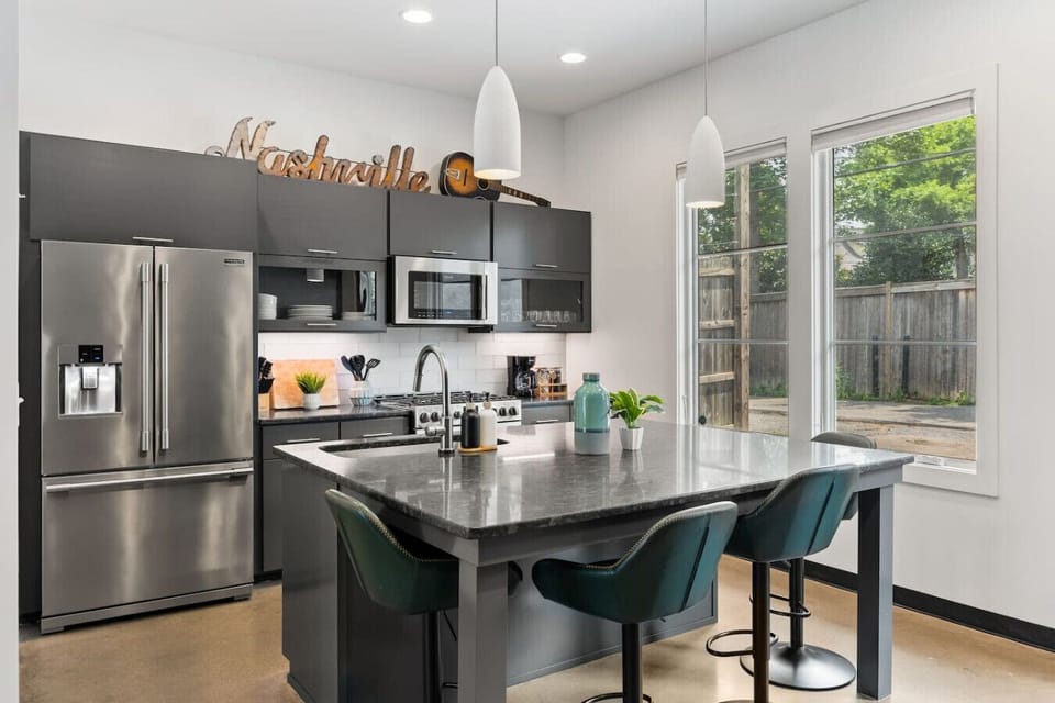 Updated, fully-equipped kitchen with high-end appliances and seating for four at the counter.