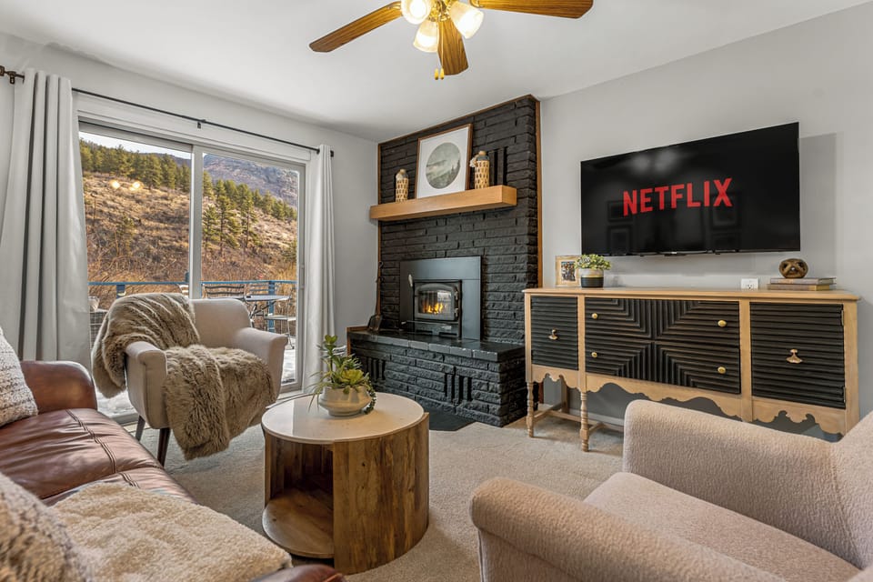 - Cozy up in the inviting living room featuring a modern black brick fireplace and soft seating
- Enjoy your favorite shows on the large screen with built in Netflix
- Sliding doors open to mountain views and fresh alpine air