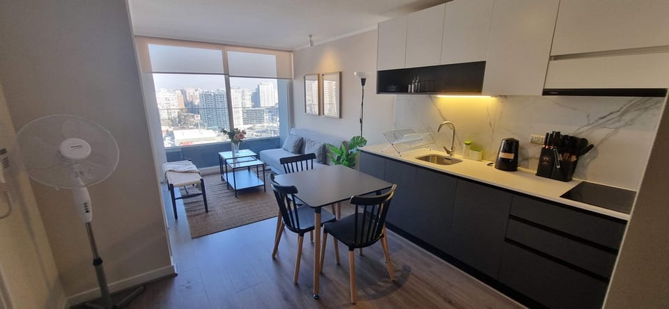 Enjoy stunning city views from this modern studio apartment with a sleek kitchen and cozy living area.