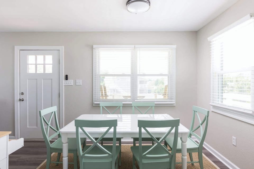 Dining Area with Seating and Large Windows, Creating a Welcoming Space for Shared Meals and Conversation