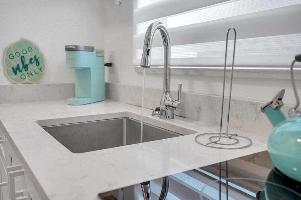 Close-up of the sink w/ sleek faucet & fresh, coastal-inspired details.