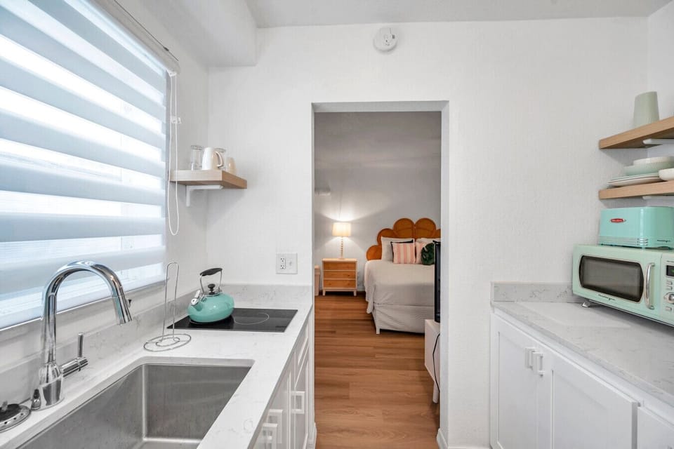 Bright kitchenette w/ compact appliances & cheerful decor for easy snacks & drinks.