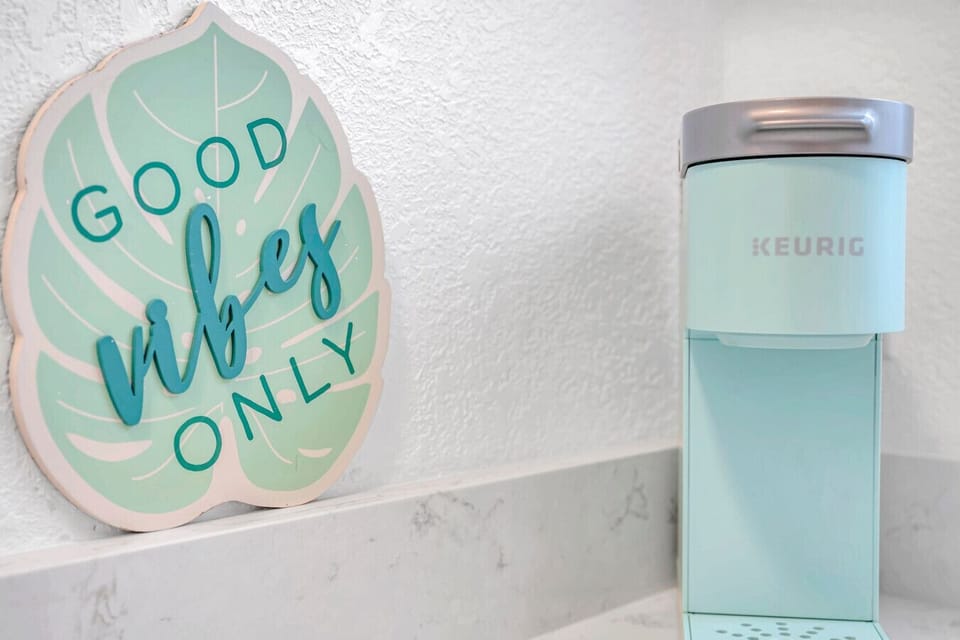 Cheerful countertop decor w/ a playful sign & colorful tumbler for a fun pop of personality.