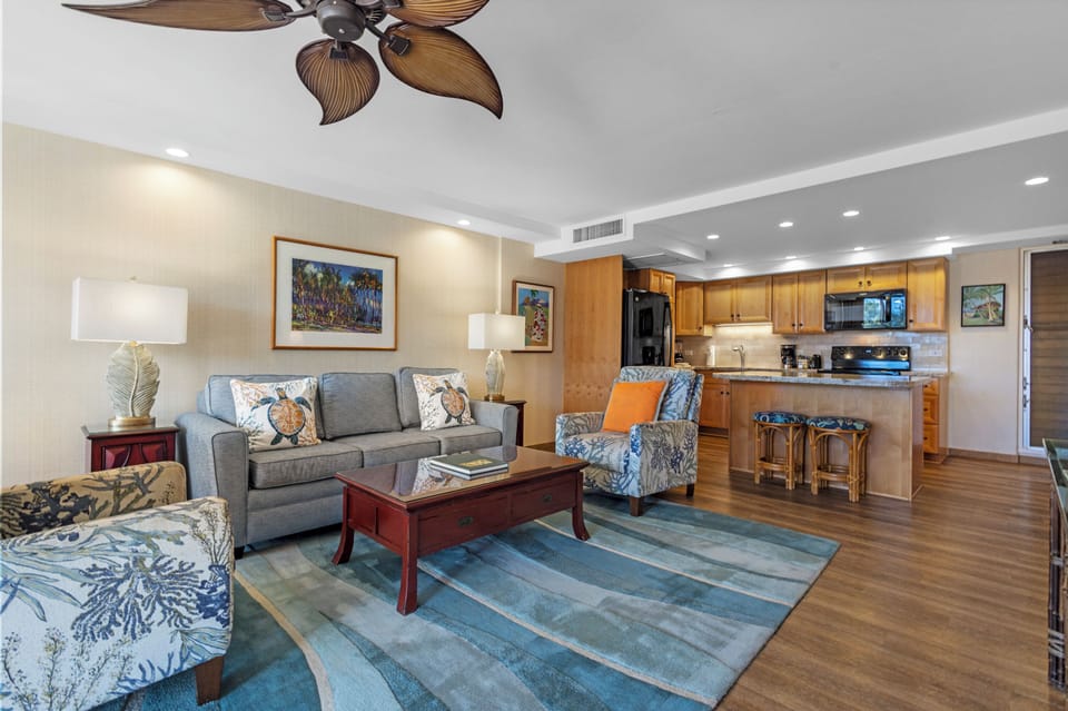 Relax in your open-concept living space with coastal décor, a tropical ceiling fan, and a fully equipped kitchen—perfect for gathering and unwinding after your island adventures.