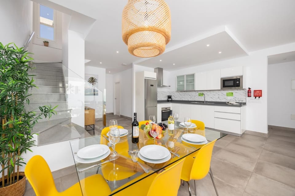 Open-plan living room with sofa, dining area, kitchen, A/C, WiFi internet, and satellite TV