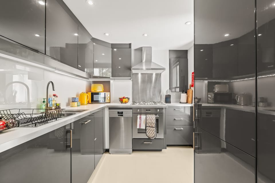 This sleek grey kitchen, accented with cheerful pops of yellow, is fully equipped with everything you need to cook comfortably away from home. A stylish and practical space for enjoying home-cooked meals during your London stay.