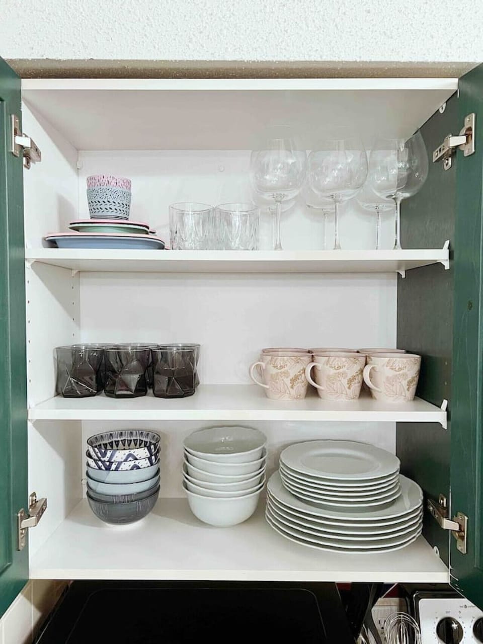 Kitchen cabinet stocked with dishes for easy meal prep.